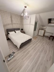 a bedroom with a large bed and a chandelier at Taverna to Petrino in Craiova