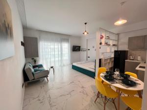 a living room with a dining table and a bedroom at Studio Sea On Beach in Mamaia