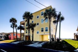 un edificio amarillo con palmeras junto a una calle en Hannah's Choice, en Edisto