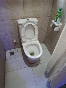 a bathroom with a toilet with the seat up at Private home with short lets in Uyo +15 photos