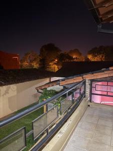 Un balcón con barandillas de metal y una valla por la noche. en Casa jardin, en Luque
