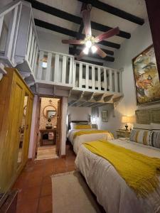 圣米格尔-德阿连德Casa Quintana的一间卧室，配有三张床和一台吊扇 更多129张照片