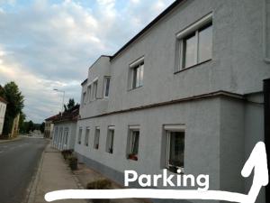 ein graues Gebäude mit der Aufschrift „Parkplatz“ in der Unterkunft Holi in Erlauf