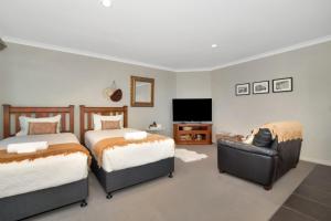 una camera da letto con due letti e una TV a schermo piatto di Parnwell Cottage a Ohauiti Altre 10 foto