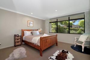 una camera da letto con un letto e una grande finestra di Parnwell Cottage a Ohauiti