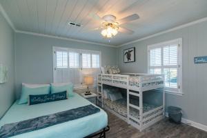 1 Schlafzimmer mit 2 Etagenbetten und einem Deckenventilator in der Unterkunft Barefoot Bungalow in Edisto Island