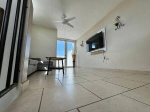 Una televisión o centro de entretenimiento en Walk to Beach • Pool • Balcony views + BBQ Grill