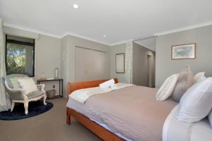 una camera da letto con un letto grande e una sedia di Parnwell Cottage a Ohauiti