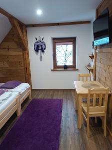 a bedroom with a bed and a table and a window at Agroturystyka nad potokiem in Domaszków