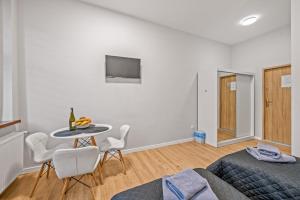 une chambre avec un lit, une table et des chaises dans l'établissement Central Platinum Apartments 4, à Rybnik