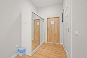 un couloir vide avec un miroir et une porte dans l'établissement Central Platinum Apartments 4, à Rybnik