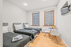 une chambre avec deux lits et une petite table dans l'établissement Central Platinum Apartments 4, à Rybnik