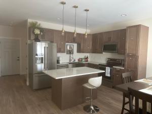 a kitchen with wooden cabinets and a stainless steel refrigerator at Luxurious Brand New Entire 3br and 2bath in Williston
