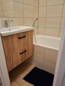 罗日尼亚瓦Apartmán Zuzka Rožňava的带水槽和浴缸的浴室