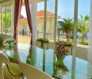 een glazen tafel met stoelen en bloemen op een balkon bij Villa Sol Los Cristianos in Los Cristianos +46 foto's