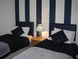 A bed or beds in a room at Glenbank House Hotel 