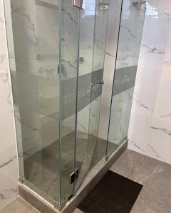 a shower with a glass door in a bathroom at LAS CONDES Hotel in Tacna