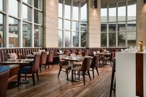 un ristorante con tavoli e sedie e grandi finestre di Archer Hotel Austin ad Austin