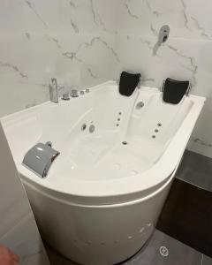 a white bath tub in a bathroom with marble walls at LAS CONDES Hotel in Tacna +24 photos