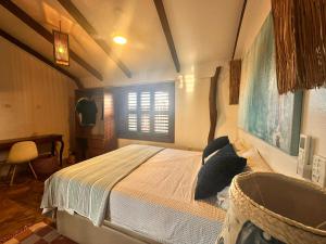 Schlafzimmer mit einem Bett, einem Fenster und einer Badewanne in der Unterkunft Refúgio prea in Cruz