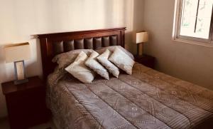 ein Schlafzimmer mit einem Bett mit Kissen und zwei Lampen in der Unterkunft Mahiahouse in Santiago