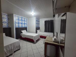 een kamer met 2 bedden en een tv. bij Hotel Danubio in Cuiabá