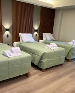 a hotel room with three beds with towels on them at LAS CONDES Hotel in Tacna