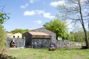 a stone house with a stone wall at Viola Nel Parco in SantʼAlfio