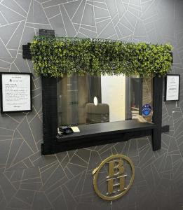 una ventana con un cartel en la pared en TBH Hotel, en Barking