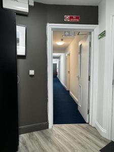 un pasillo de un edificio de oficinas con una puerta abierta en TBH Hotel, en Barking