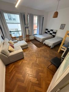 sala de estar con 2 camas y suelo de madera en HouseCheconquista, en Buenos Aires