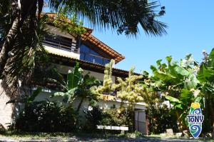 a building with a palm tree in front of it at Tony Pousada Hotel Geribá in Búzios