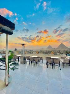 un patio con mesas y sillas y vistas a las pirámides. en Anyma Pyramids View Inn, en El Cairo