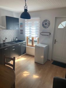 a kitchen with a refrigerator and a table and a window at Appartement F1 in Mauriac