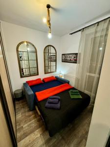 a bedroom with a large bed and two mirrors at LOFT Studio Wielicka in Krakow