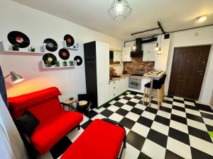 a living room with a red couch and a checkered floor at LOFT Studio Wielicka in Krakow