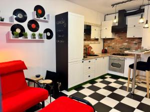 a kitchen with a red chair and records on the wall at LOFT Studio Wielicka in Krakow +27 photos