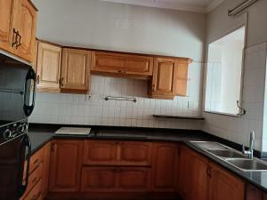 a kitchen with wooden cabinets and a black counter top at Nsimbini 430 Lena Ahrens in Durban