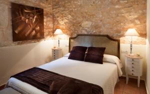 Casa Rural Mirador في بوكايرينت: غرفة نوم مع سرير مع مواقف ليلتين ومصباحين