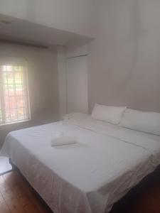 a large white bed in a white room with a window at Nsimbini 430 Lena Ahrens in Durban