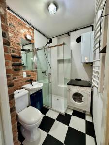 a bathroom with a toilet and a sink and a shower at LOFT Studio Wielicka in Krakow