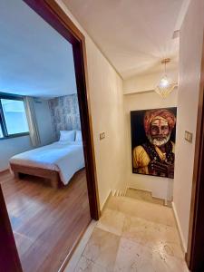 马拉喀什Cosy Duplex, dans résidence avec piscine的一间设有一张床的客房,墙上挂着一幅画