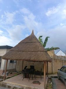 una mesa y sillas bajo una sombrilla de paja en Private home with short lets, en Uyo
