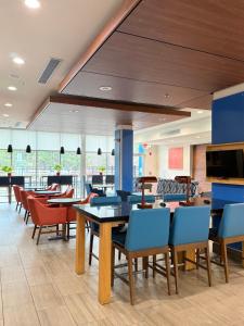 a restaurant with tables and chairs in a cafeteria at Holiday Inn Express - Bethlehem by IHG in Winder
