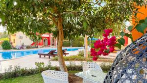 a resort with a pool and a tree with pink flowers at Green Garden Resort in Hurghada