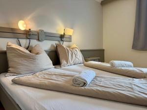 two beds in a room with white sheets and pillows at Gasthaus Paus in Götzendorf an der Leitha