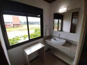 ein Badezimmer mit Waschbecken und Fenster in der Unterkunft Pousada Divino Oleiro - Gov. Celso Ramos in Governador Celso Ramos + 44 Fotos