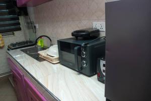 un forno a microonde seduto sopra un bancone della cucina di feel at home luxury suit a Sekondi-Takoradi Altre 4 foto