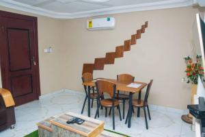 una sala da pranzo con tavolo, sedie e scala di feel at home luxury suit a Sekondi-Takoradi