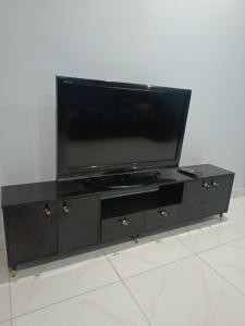 Un centro de entretenimiento negro con un televisor de pantalla plana. en Private home with short lets, en Uyo
